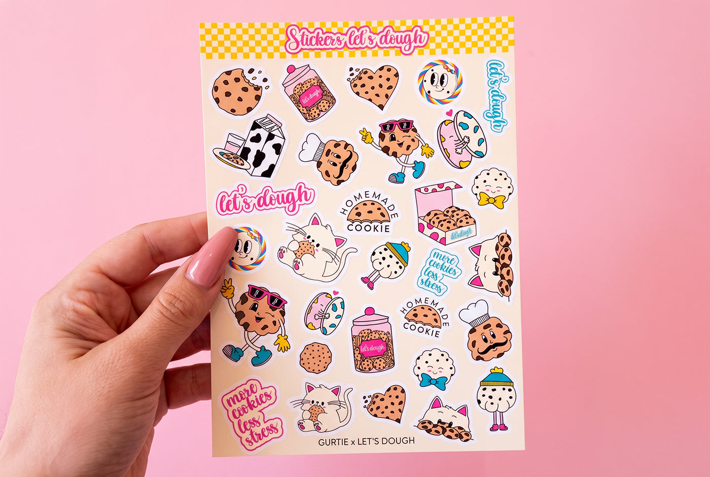 La planche de stickers Let's Dough dans une main sur fond rose